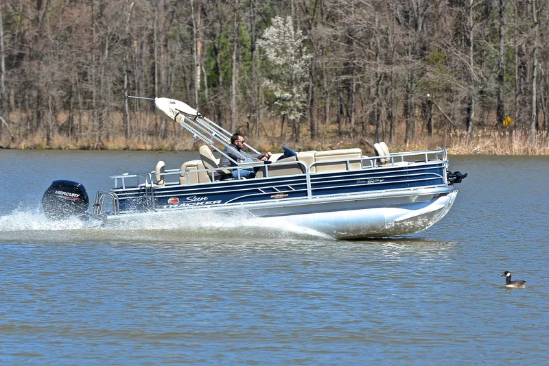 Slide: The Image of 2023 Sun Tracker Fishin Barge 20 DLX cruising on a lake with trees in the background. - 3