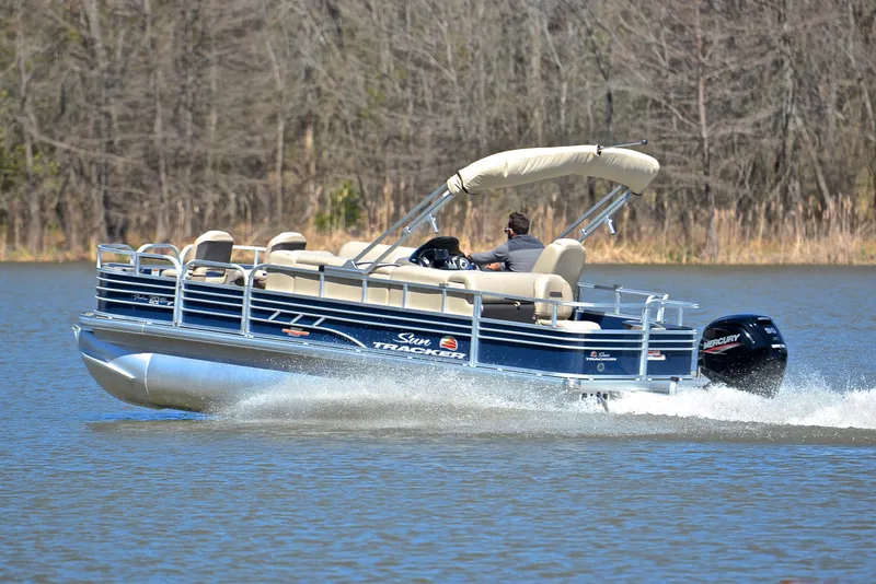 Slide: The Image of 2023 Sun Tracker Fishin Barge 20 DLX pontoon boat cruising on a lake. - 4