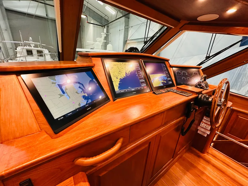 Slide: The Image of 2017 Sabre Salon Express helm with navigation screens and wooden dashboard. - 16