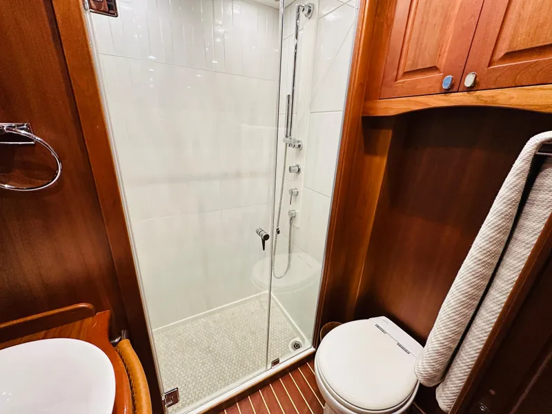Slide: The Image of 2017 Sabre Salon Express bathroom with shower, wooden cabinetry, and modern fixtures. - 38