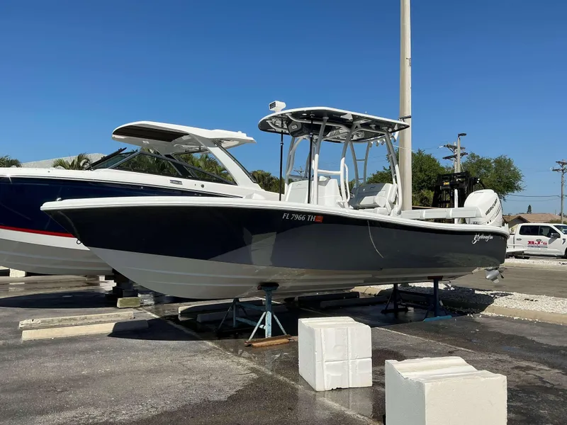 Slide: The Image of 2023 Yellowfin 26 CC Hybrid boat on display under clear blue sky. - 1