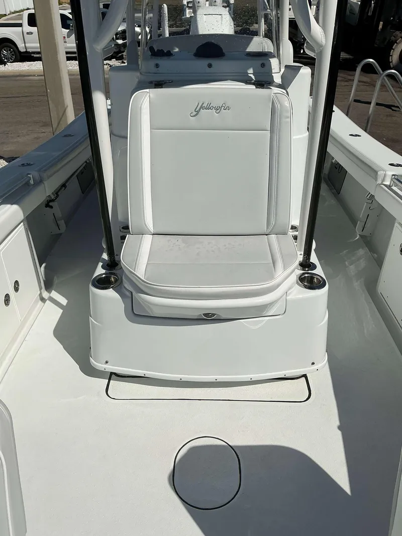 Slide: The Image of 2023 Yellowfin 26 CC Hybrid boat interior with white seating and console. - 17