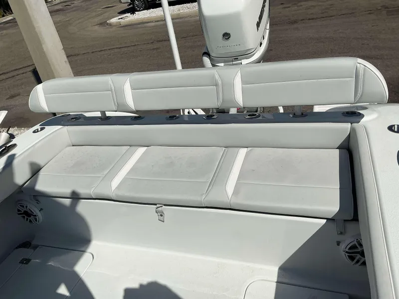 Slide: The Image of 2023 Yellowfin 26 CC Hybrid boat interior with cushioned seating and rod holders. - 18
