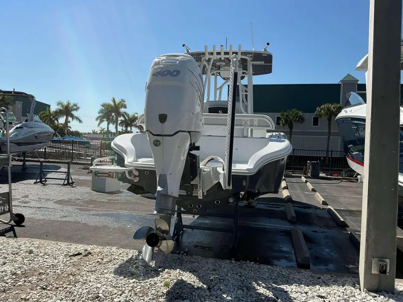 Slide: The Image of 2023 Yellowfin 26 CC Hybrid boat with powerful outboard motor, parked in marina. - 2