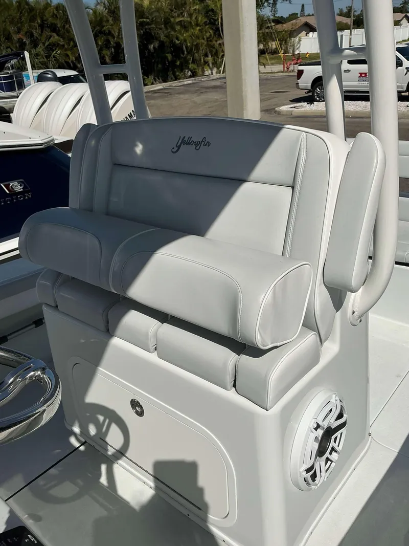 Slide: The Image of 2023 Yellowfin 26 CC Hybrid boat seat with white upholstery and speaker. - 20