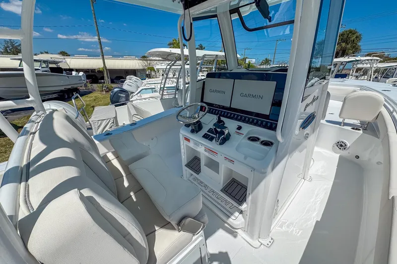 Slide: The Image of 2025 Sea Hunt Gamefish 28 FS boat interior with Garmin displays and white seating. - 5