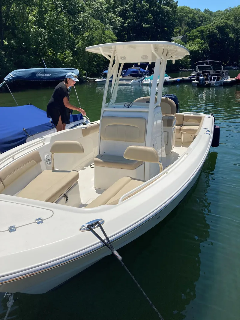 Slide: The Image of 2017 Sailfish 236 CC boat docked on a sunny day, featuring beige seating and a T-top. - 4