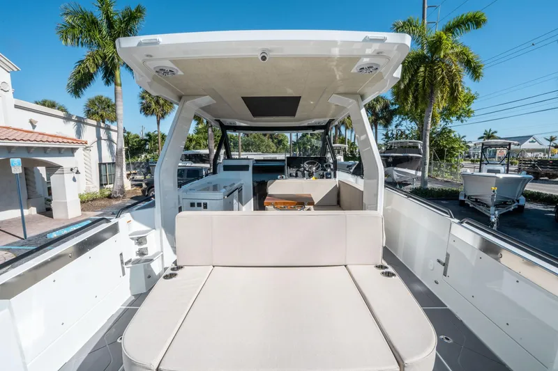 Slide: The Image of 2025 Quarken 35 Sport Tourer boat with spacious seating, docked under clear blue skies. - 9