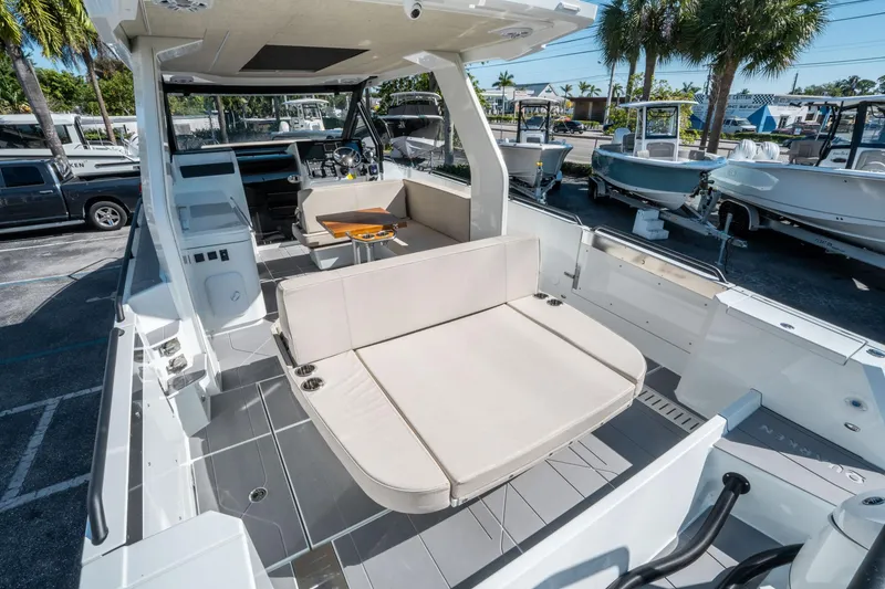 Slide: The Image of 2025 Quarken 35 Sport Tourer boat interior with seating and helm, parked outdoors. - 10