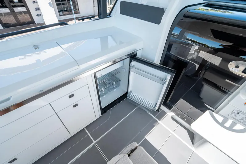 Slide: The Image of Interior of 2025 Quarken 35 Sport Tourer with open mini fridge and sleek cabinetry. - 23