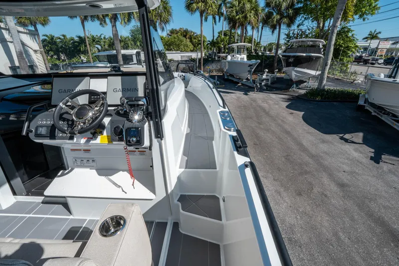 Slide: The Image of 2025 Quarken 35 Sport Tourer boat interior with Garmin navigation, parked outdoors. - 28
