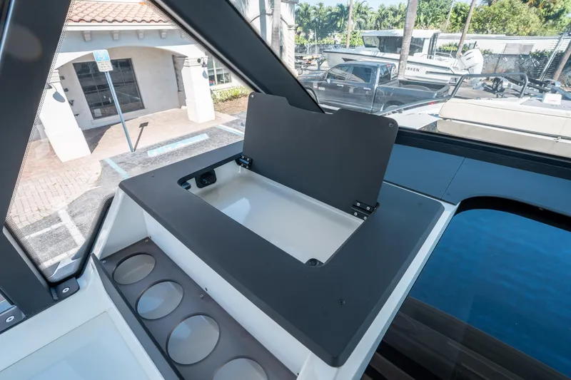 Slide: The Image of Interior view of 2025 Quarken 35 Sport Tourer boat, featuring storage compartment and cup holders. - 33