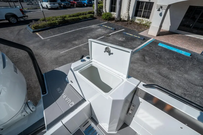 Slide: The Image of 2025 Quarken 35 Sport Tourer boat with open storage compartment in a parking lot. - 12