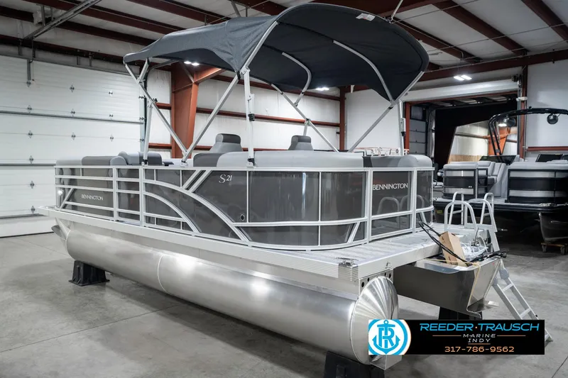 Slide: The Image of 2025 Bennington 21 SSR pontoon boat in showroom with canopy and sleek design. - 10