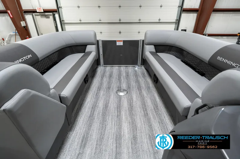 Slide: The Image of 2025 Bennington 21 SSR boat interior with gray seating and flooring in a showroom. - 22