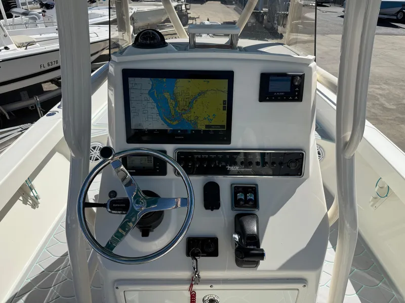 Slide: The Image of 2018 Pathfinder 2600 TRS boat dashboard with navigation screen and steering wheel. - 13
