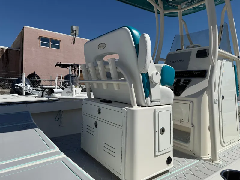 Slide: The Image of 2018 Pathfinder 2600 TRS boat interior with seating and console, docked outdoors. - 5
