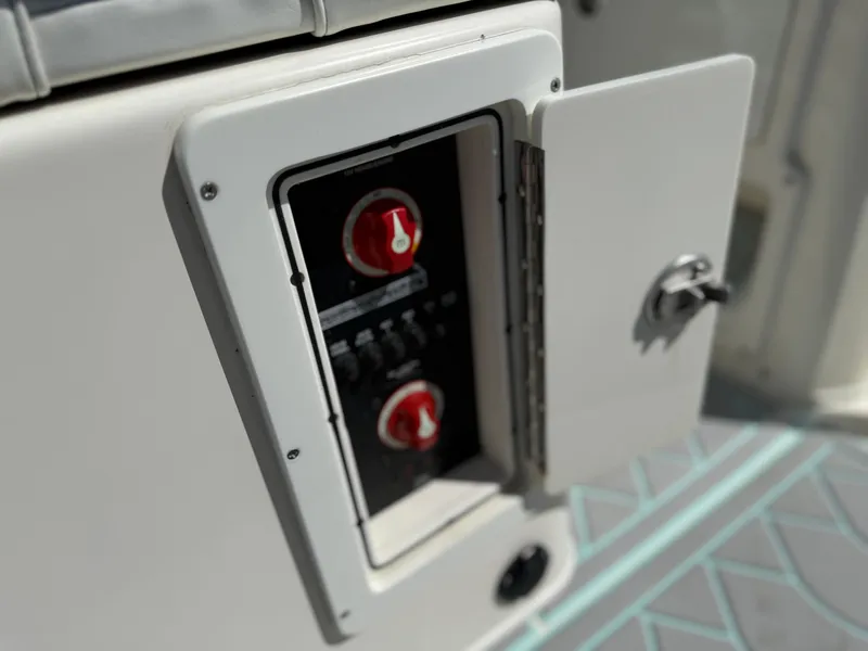 Slide: The Image of Open electrical panel on 2018 Pathfinder 2600 TRS boat, showing red switches. - 6