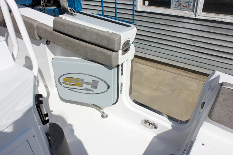 Slide: The Image of 2025 Sea Hunt Ultra 255 SE boat interior with cushioned seating and storage compartment. - 24
