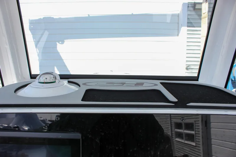 Slide: The Image of Dashboard of 2025 Sea Hunt Ultra 255 SE boat with compass and storage area. - 36