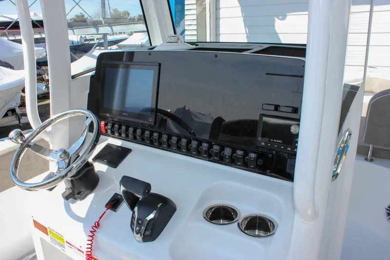 Slide: The Image of 2025 Sea Hunt Ultra 255 SE boat dashboard with steering wheel and controls. - 4
