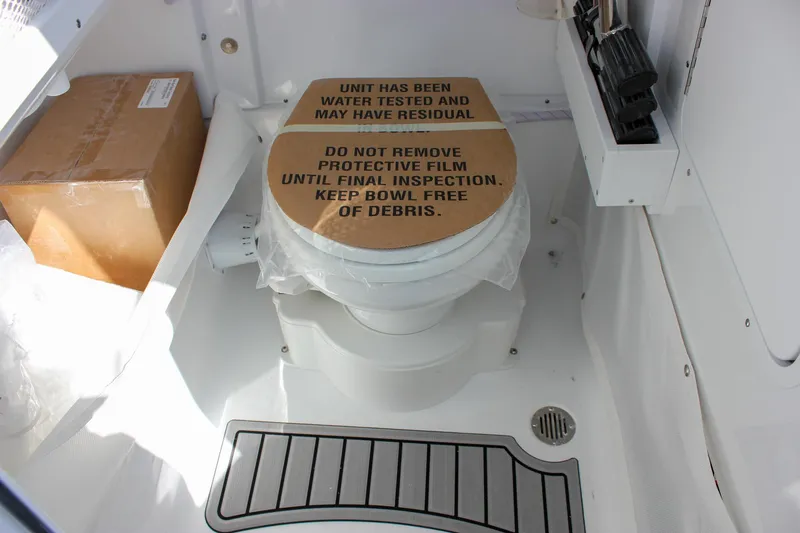 Slide: The Image of 2025 Sea Hunt Ultra 255 SE boat toilet with protective cover and inspection instructions. - 42