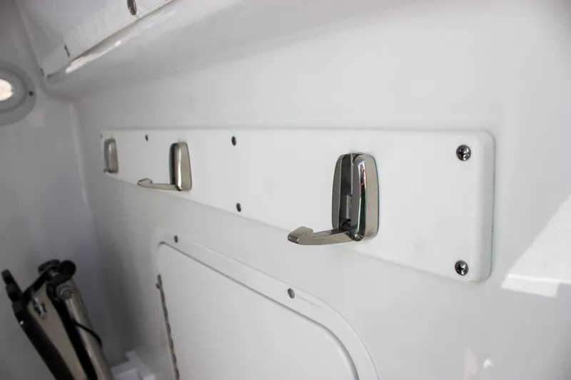 Slide: The Image of 2025 Sea Hunt Ultra 255 SE interior with mounted hooks and storage compartment. - 43