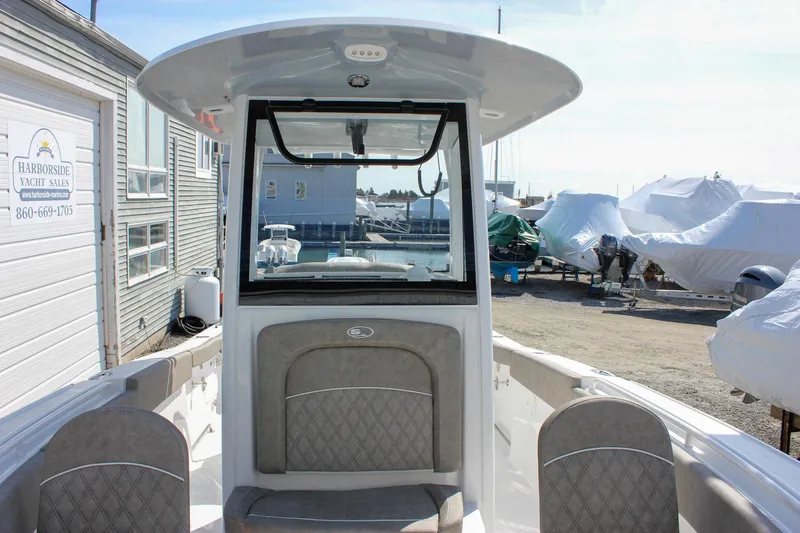 Slide: The Image of 2025 Sea Hunt Ultra 255 SE boat interior with cushioned seating and console. - 49