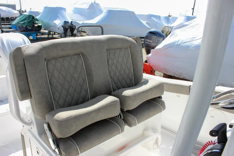 Slide: The Image of 2025 Sea Hunt Ultra 255 SE boat seats with diamond stitching, docked with covered boats. - 6