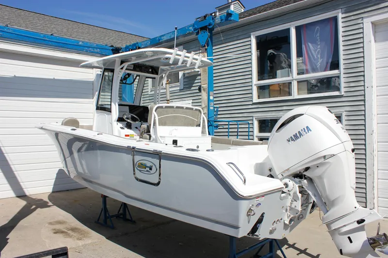 Slide: The Image of 2025 Sea Hunt Ultra 255 SE boat with Yamaha engine, parked outdoors. - 7