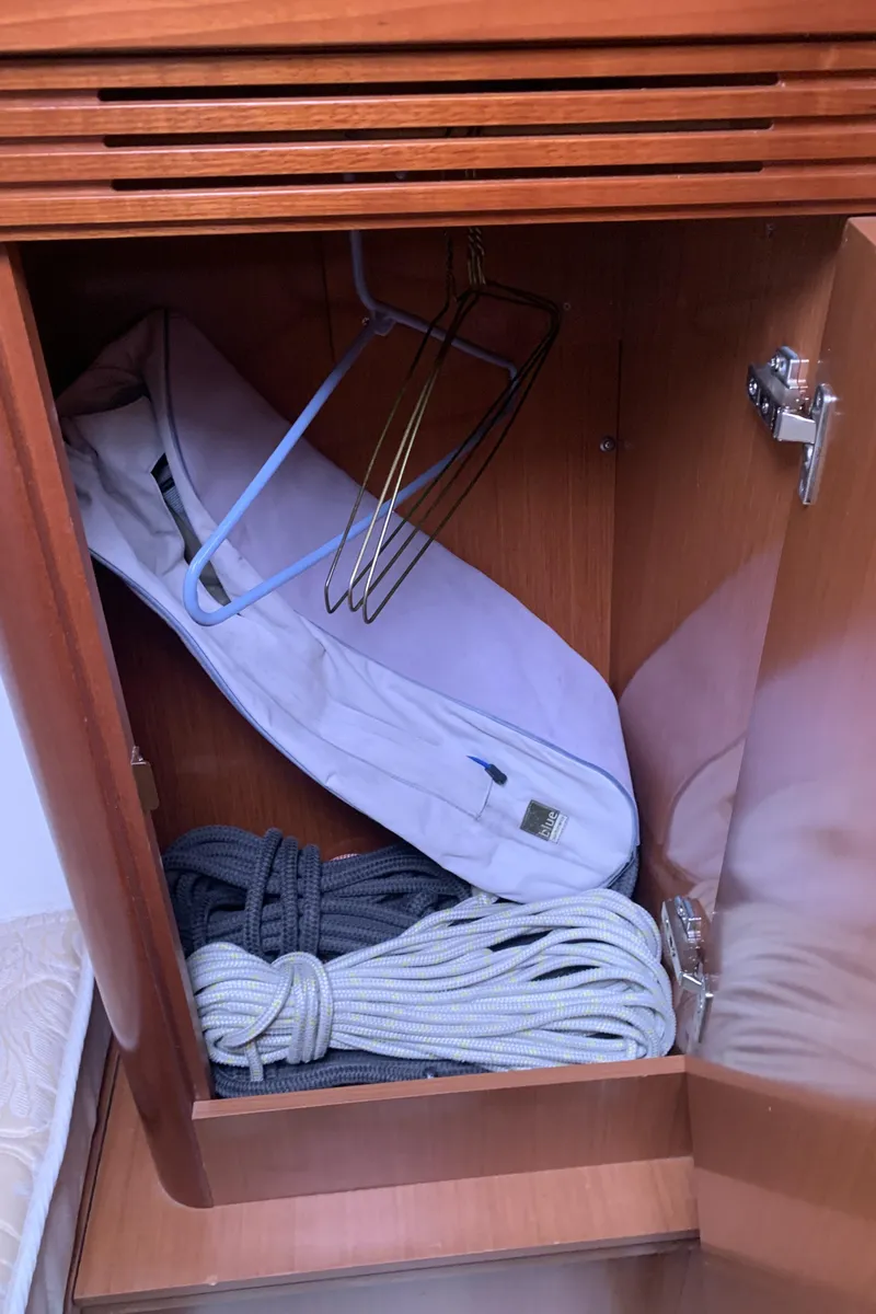Slide: The Image of Storage cabinet in 2010 Beneteau Oceanis 31 sailboat with ropes and hangers. - 23