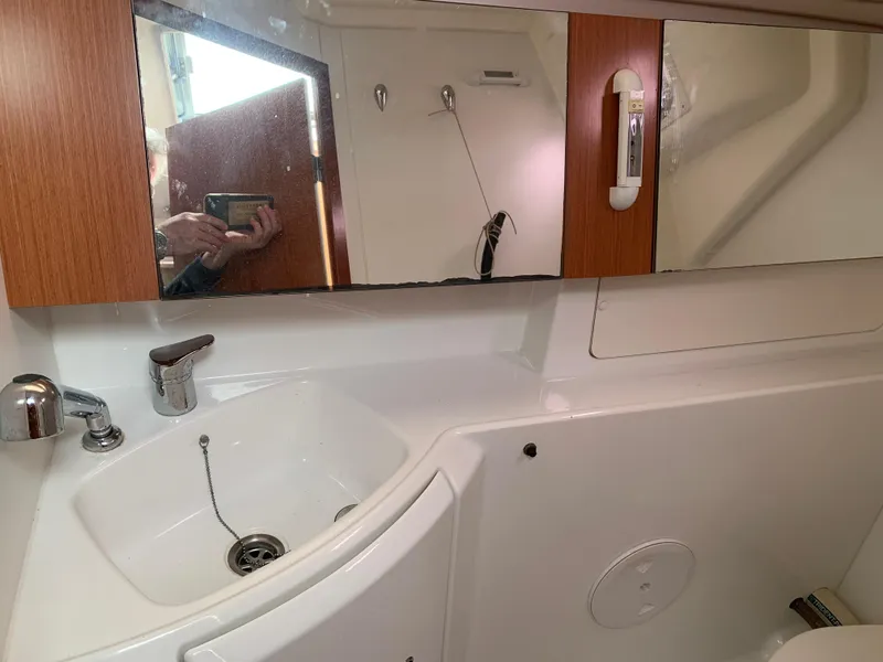 Slide: The Image of Beneteau Oceanis 31 bathroom interior, featuring a sink and mirrored cabinet, 2010 model. - 27