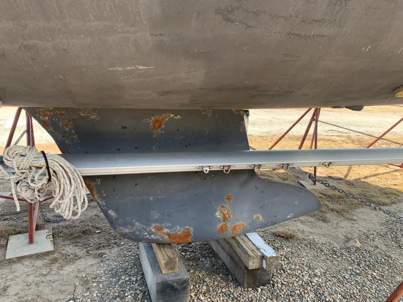 Slide: The Image of 2010 Beneteau Oceanis 31 keel with visible rust and ropes, on dry dock. - 38