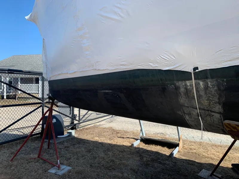 Slide: The Image of 2010 Beneteau Oceanis 31 sailboat on stands, partially covered, outdoors. - 39