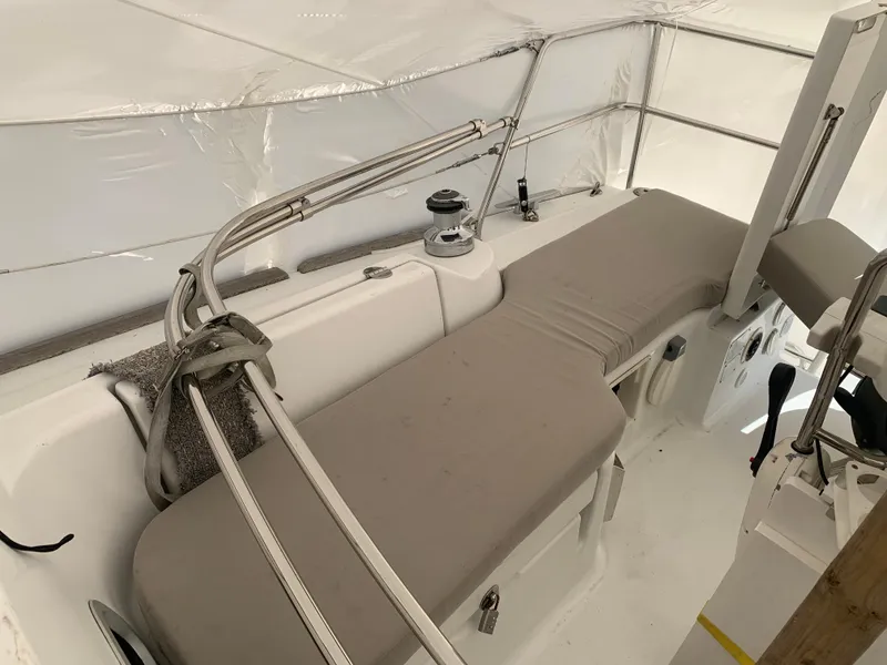 Slide: The Image of 2010 Beneteau Oceanis 31 cockpit with beige cushions and winch, under protective cover. - 49