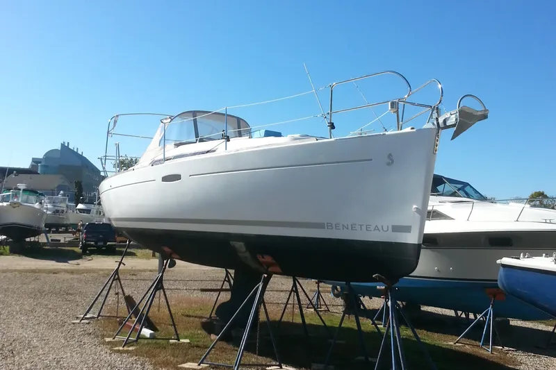 Slide: The Image of 2010 Beneteau Oceanis 31 sailboat on stands, displayed outdoors under clear blue sky. - 8