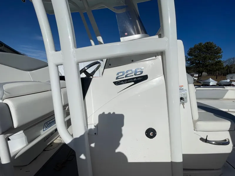 Slide: The Image of 2022 Robalo 226 Cayman boat console with seating, under clear blue sky. - 11