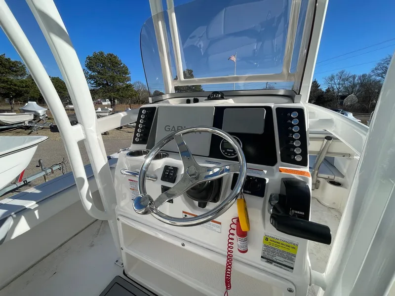 Slide: The Image of 2022 Robalo 226 Cayman boat dashboard with steering wheel and controls. - 12
