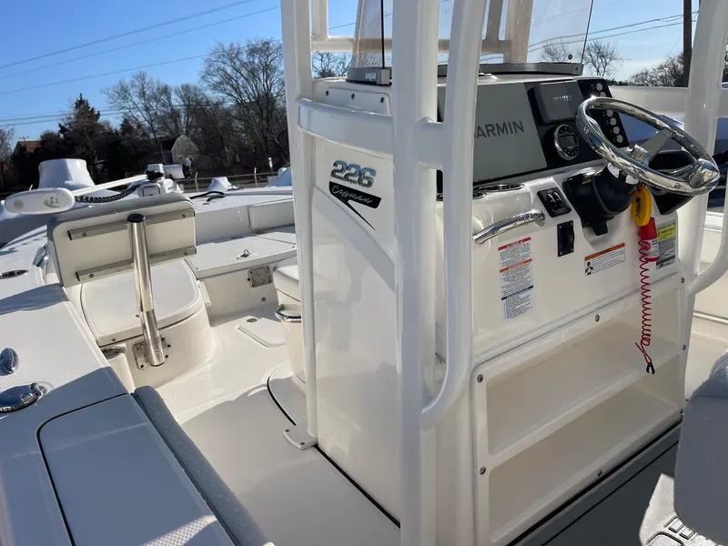 Slide: The Image of 2022 Robalo 226 Cayman boat interior with steering console and seating. - 14