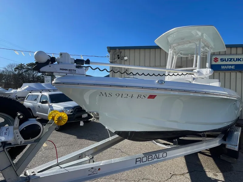 Slide: The Image of 2022 Robalo 226 Cayman boat on trailer, parked outside Suzuki Marine dealership. - 4