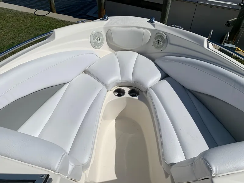 Slide: The Image of 2009 Bayliner 205 boat interior with white cushioned seating and cup holders. - 3