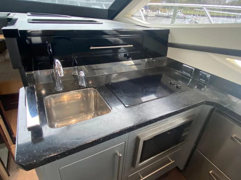 Slide: The Image of 2010 Marquis 500 Sport Bridge yacht kitchen with modern appliances and sleek black countertops. - 10