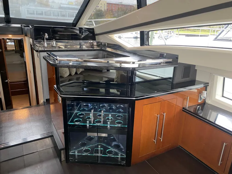 Slide: The Image of Luxurious interior of 2010 Marquis 500 Sport Bridge yacht with modern kitchen and bar area. - 13