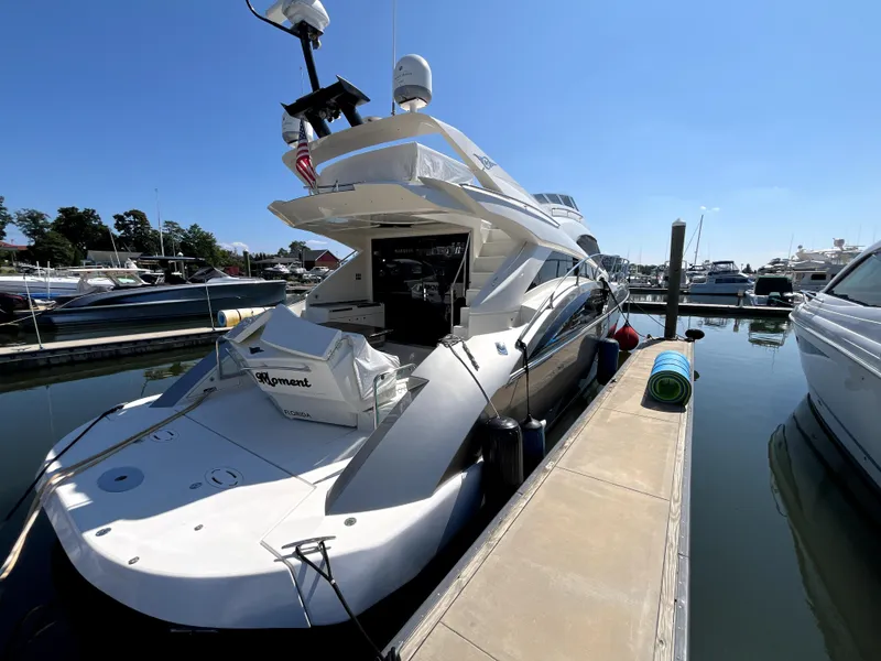 Slide: The Image of 2010 Marquis 500 Sport Bridge yacht docked at marina under clear blue sky. - 17