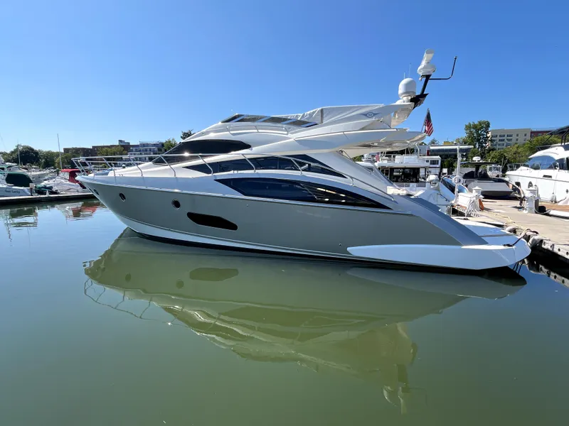 Slide: The Image of 2010 Marquis 500 Sport Bridge yacht docked in a marina under clear blue skies. - 18
