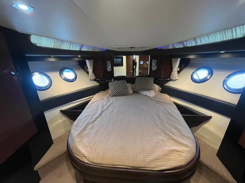 Slide: The Image of Luxurious cabin interior of 2010 Marquis 500 Sport Bridge yacht with cozy bed and porthole windows. - 19