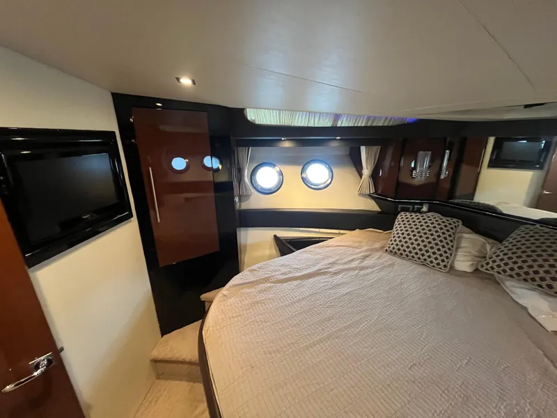 Slide: The Image of Luxurious interior of 2010 Marquis 500 Sport Bridge yacht with cozy bedroom and porthole windows. - 21