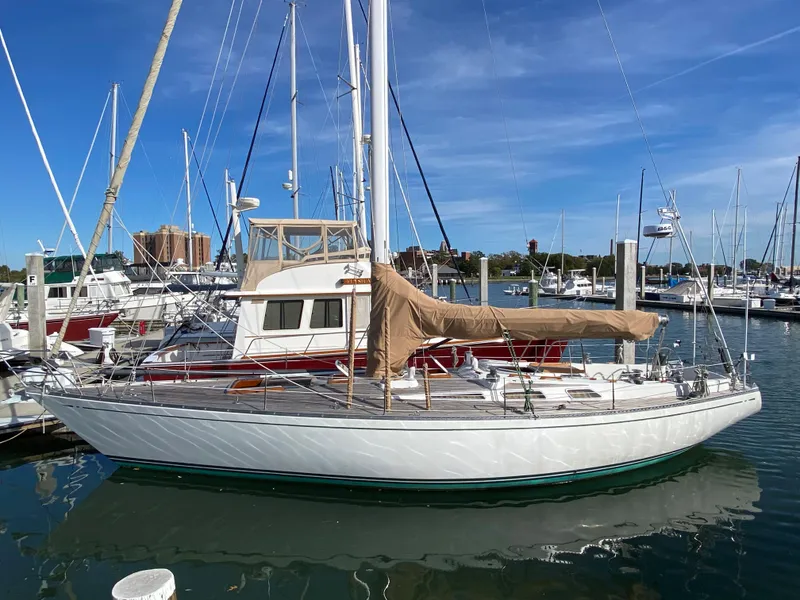 Slide: The Image of 1973 Nautor Swan 44 sailboat docked in a marina under clear blue skies. - 0
