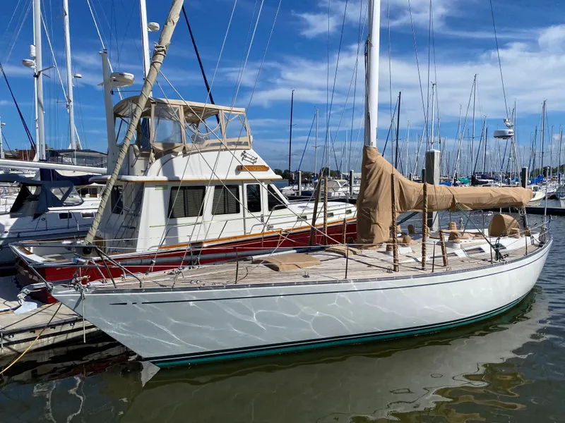 Slide: The Image of 1973 Nautor Swan 44 sailboat docked in a marina under a clear blue sky. - 1