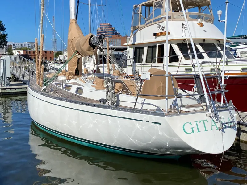 Slide: The Image of 1973 Nautor Swan 44 sailboat docked at marina, reflecting on water. - 2
